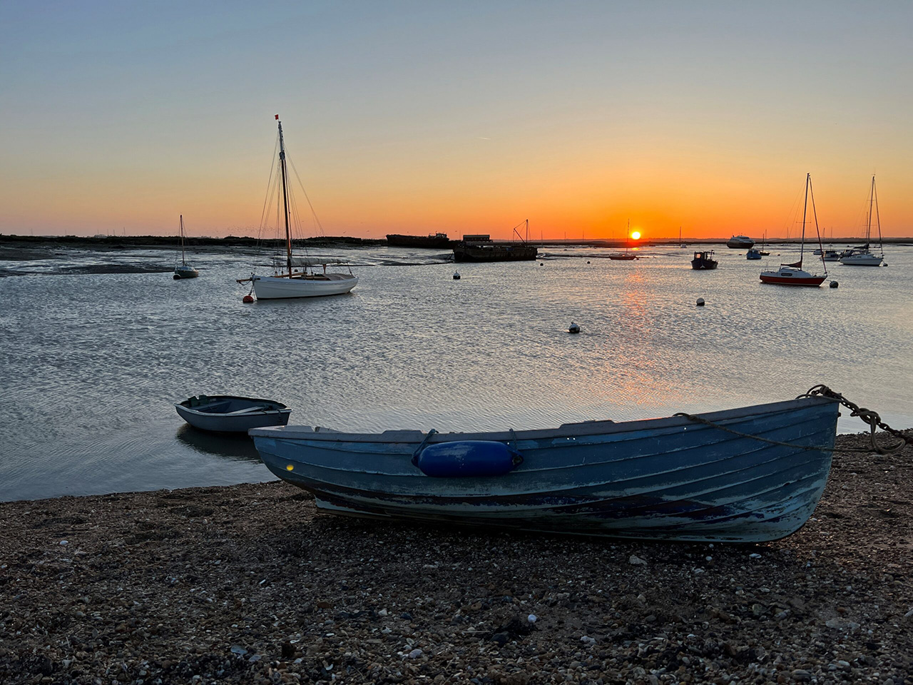 Sail boat on the beach at sunset.